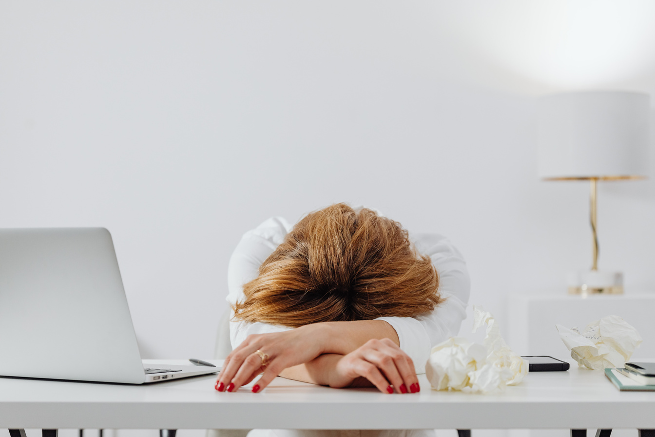 Woman Resting at a Table Beside a Laptop